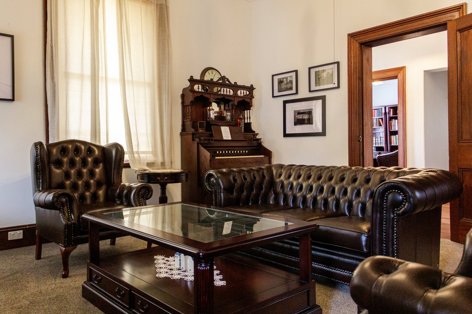 The homestead's front parlour, with its original marble fireplace, chesterfield lounges and heritage furnishings.